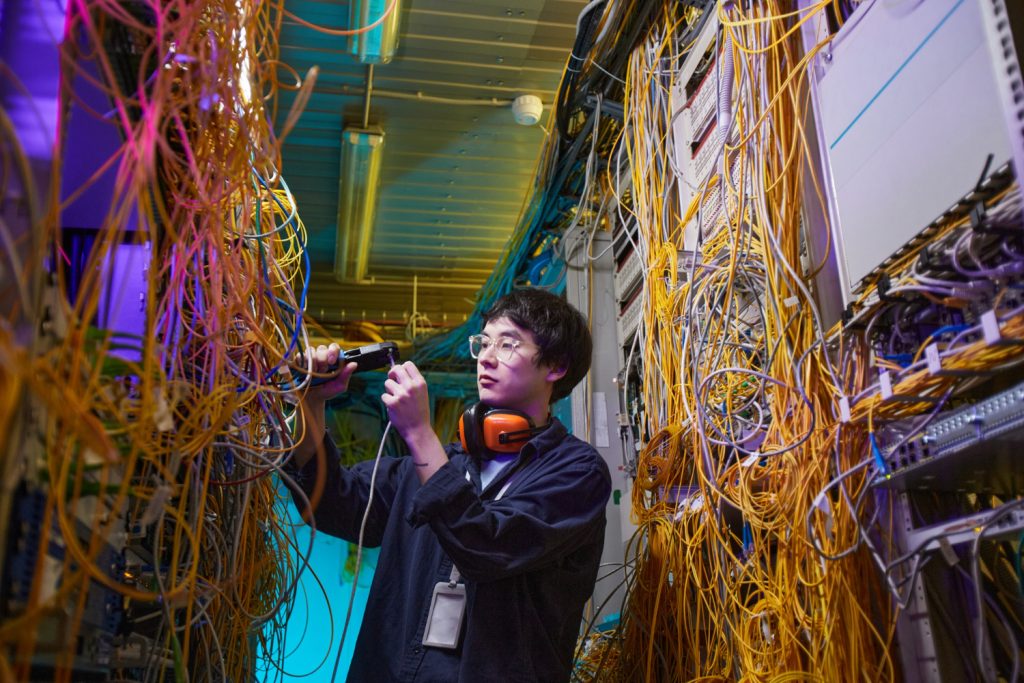 waist up portrait young network technician connecting cables server room copy space - Jasa Mikrotik